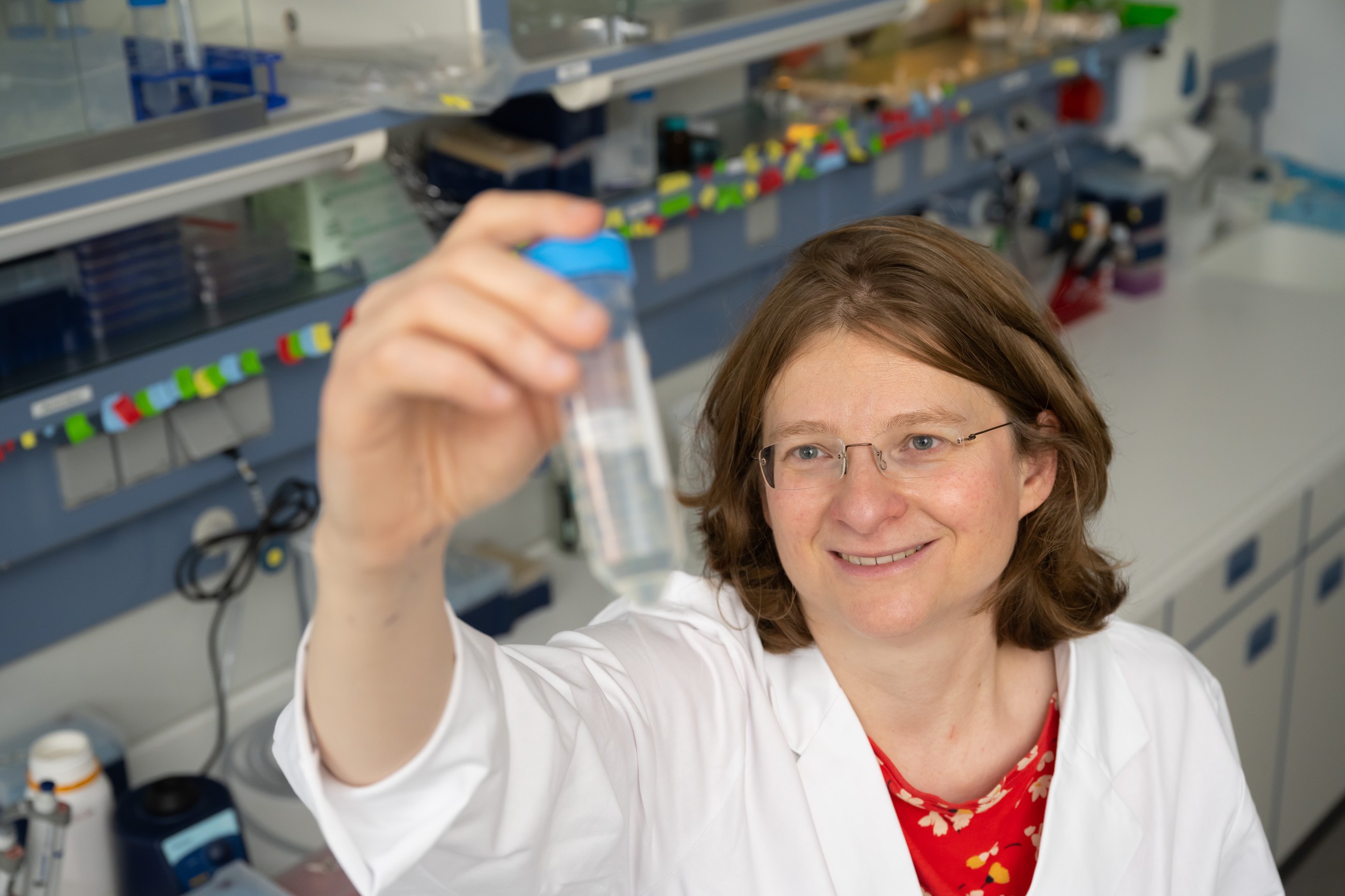 Researcher holding a sample container in a laboratory